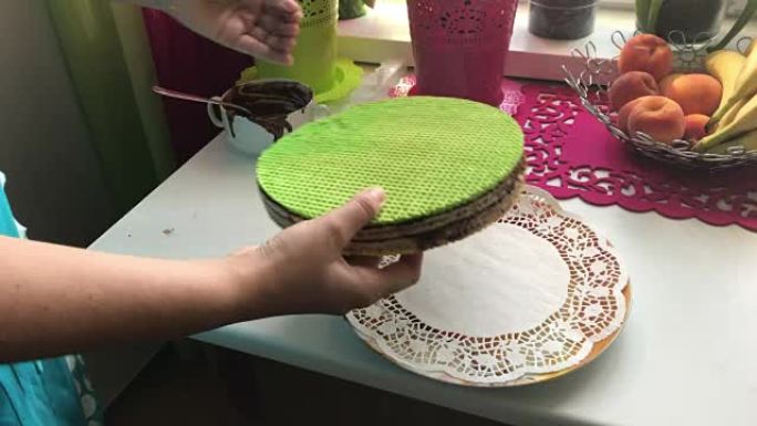 一个女人把完成的威化饼放在盘子上。华夫饼蛋糕配煮炼乳和巧克力。烹饪过程。威化饼、可可和炼乳是烹饪的原