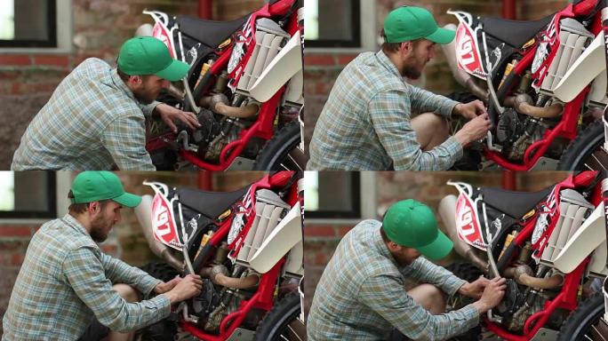 男运动员修理他的耐力赛摩托车