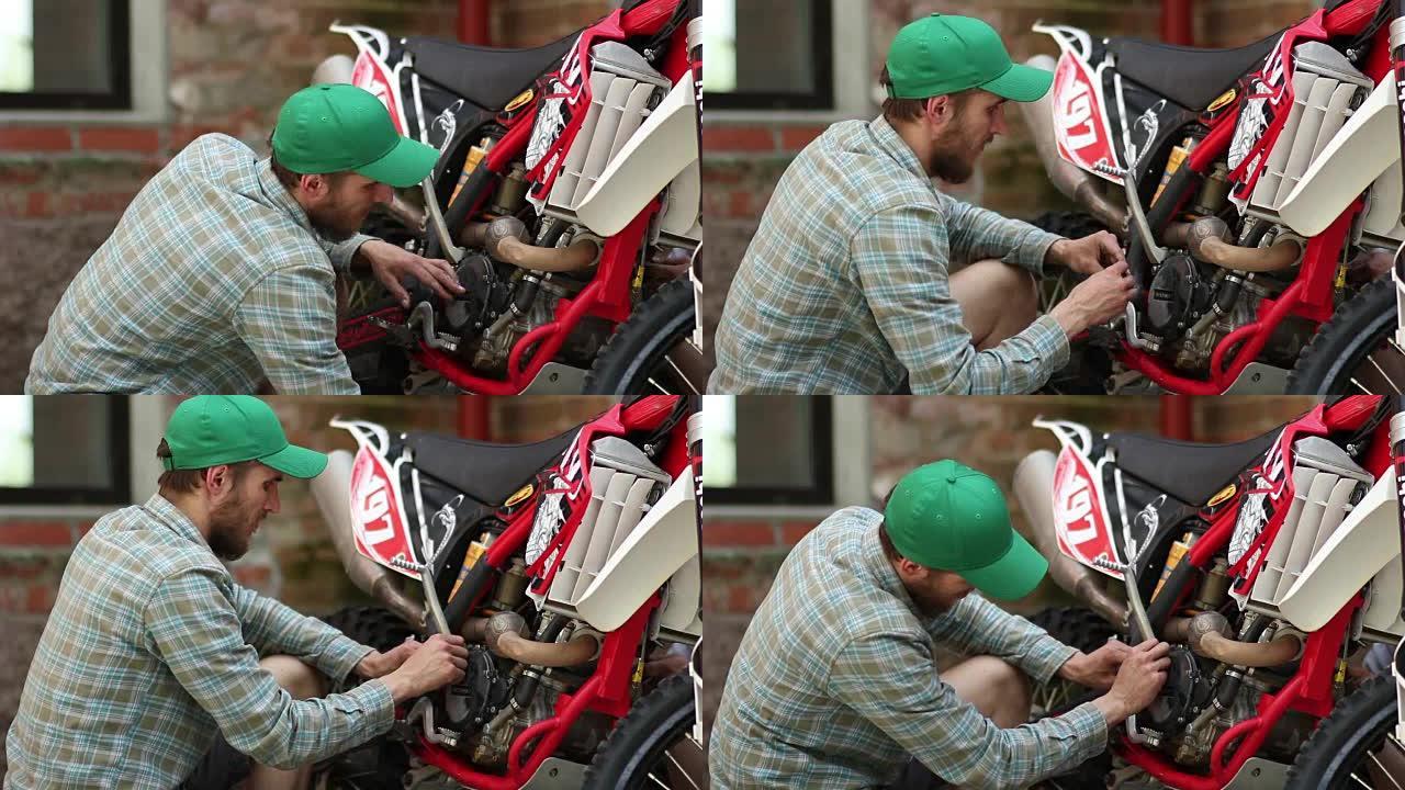 男运动员修理他的耐力赛摩托车