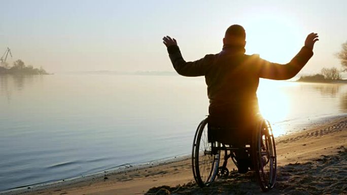 残疾人举起双手，日落，孤独