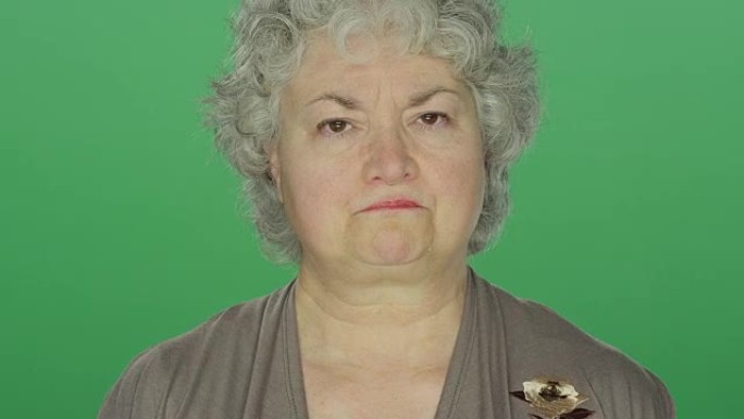在绿屏工作室背景上，看起来沮丧的老女人