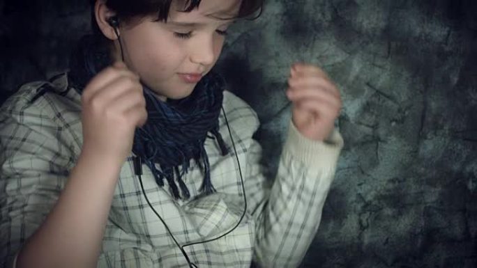 4k高科技拍摄了一个孩子为音乐设置智能手机和耳机的照片