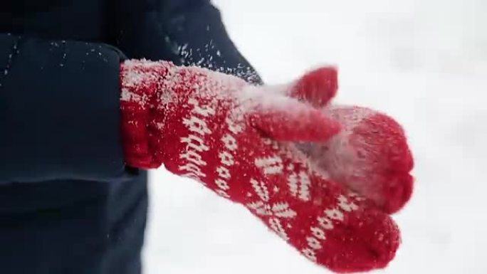 穿着红色手套的女孩摆脱了积雪