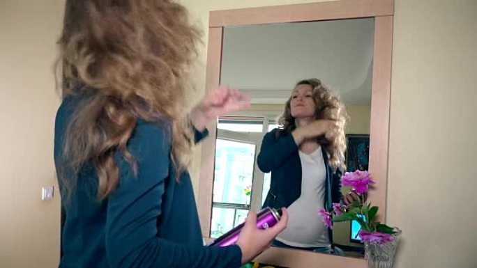 孕妇美女用发胶照镜子爱抚头发