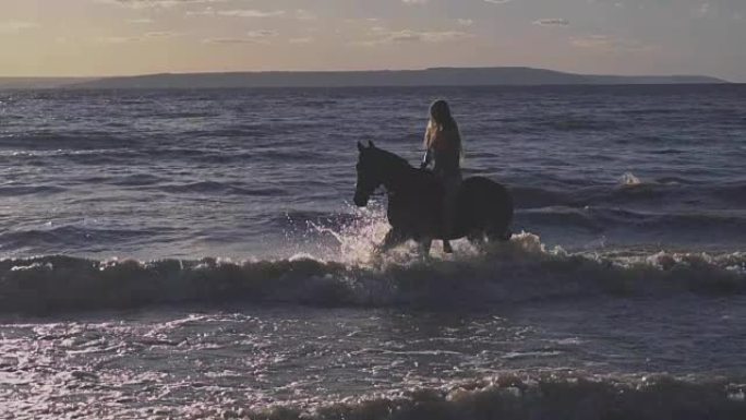 年轻性感的女人穿着比基尼在河水中骑马