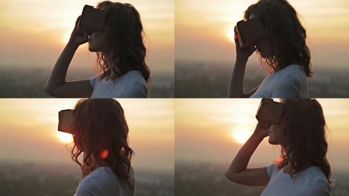 女人在日落时使用虚拟现实眼镜