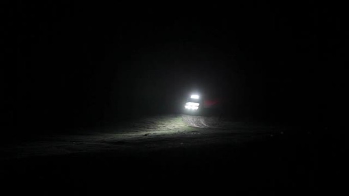 远征越野车在黑暗中开着前灯骑在山上。