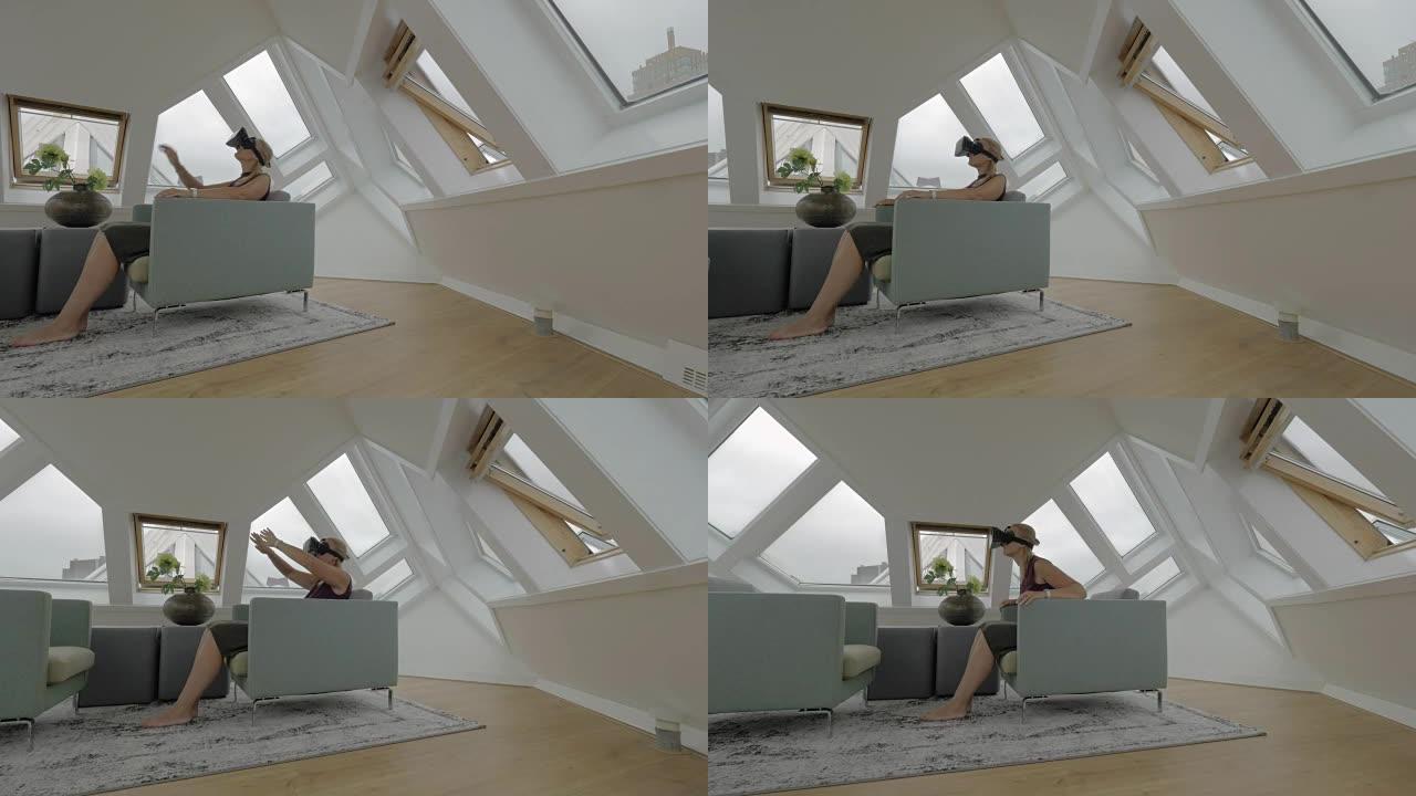 坐在扶手椅边的年轻金发女子在房间内使用平板电脑在立方体房子的视图。荷兰鹿特丹