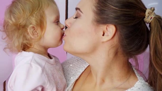 母亲亲吻女儿，分享温柔和爱的时刻