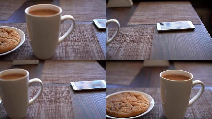 桌上摆着饼干，一杯可可和一部智能手机