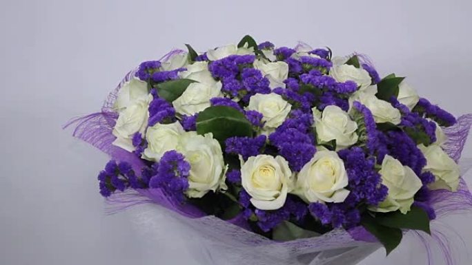 紫罗兰装饰的白玫瑰花束