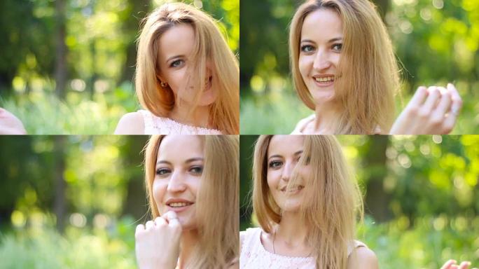 空气之吻。微笑的金发女人在夏日公园炫耀她郁郁葱葱的长发