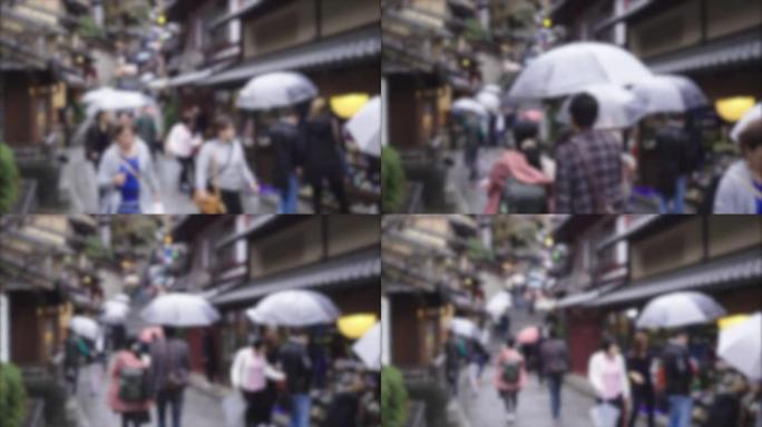 游客们在京都打着雨伞走在街上下雨
