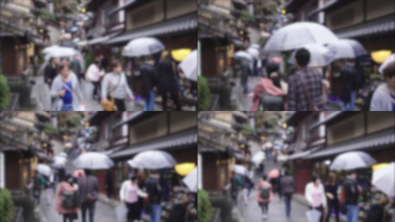 游客们在京都打着雨伞走在街上下雨