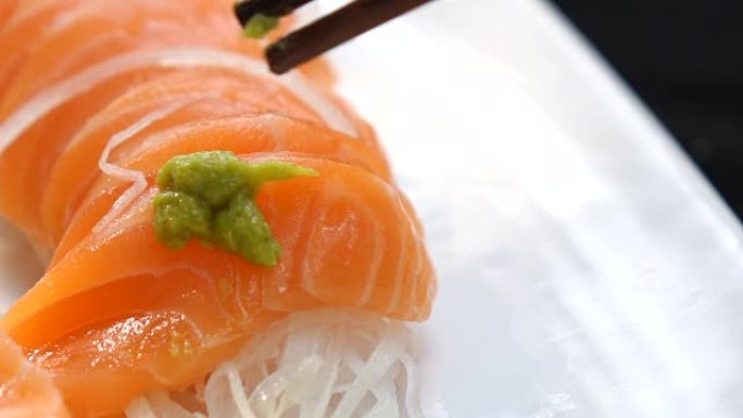 筷子拿起三文鱼生鱼片日本食品