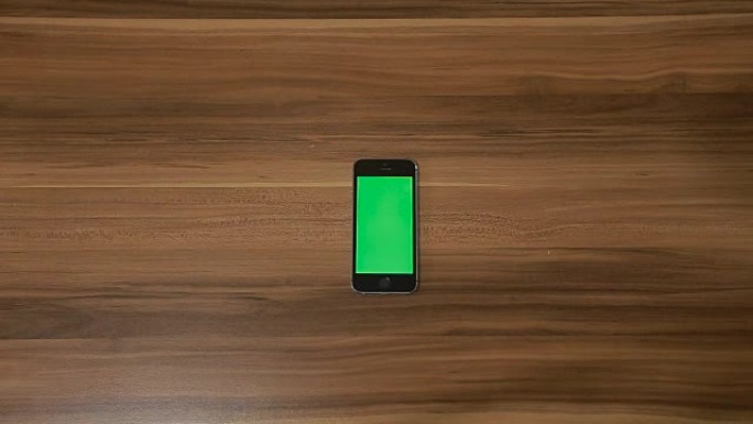 智能手机在木桌背景上滑动手势。垂直