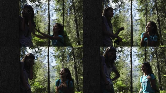 女人在阳光明媚的森林里开玩笑吓唬朋友摄影师。一群朋友夏季户外探险之旅。探索阿尔卑斯山，多洛米蒂，意大