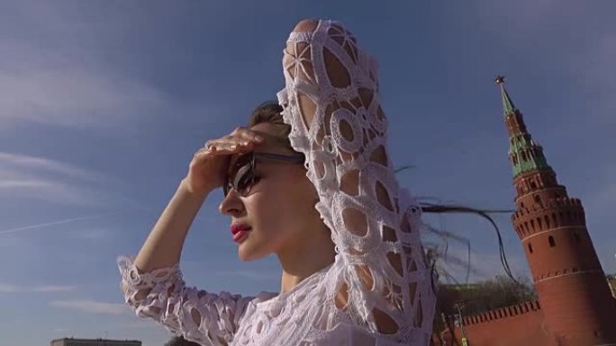 穿着白色连衣裙的年轻美女站在经过莫斯科克里姆林宫的船甲板上。全高清视频