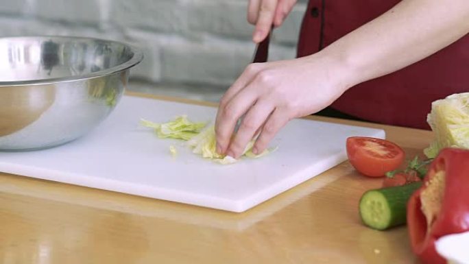 男人用手在白板上用刀切白菜。慢慢地