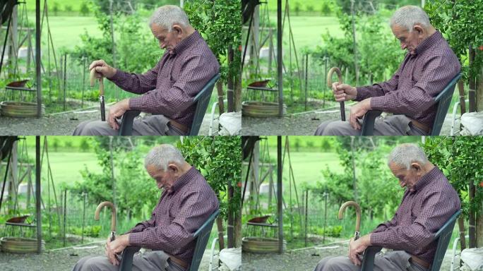 疲惫的老人独自坐在户外的乡村绿色背景