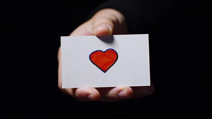 一只手展示了一张浪漫的卡片，上面写着 “我爱它”。概念: 爱，帮助他人，喜欢，激情，分享。