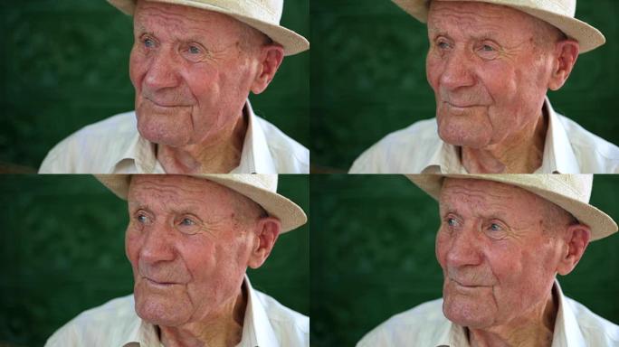很有感情的老人肖像。祖父开心而微笑。肖像: 老年人，老年人。夏天，一个戴着白帽子的沉思老人独自坐在户