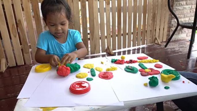 有趣的小女孩，为孩子们玩面团模型粘土