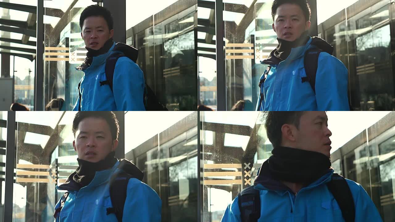 亚洲背包客男子在电车车站慢动作120 fps拍摄时看起来困惑和迷失