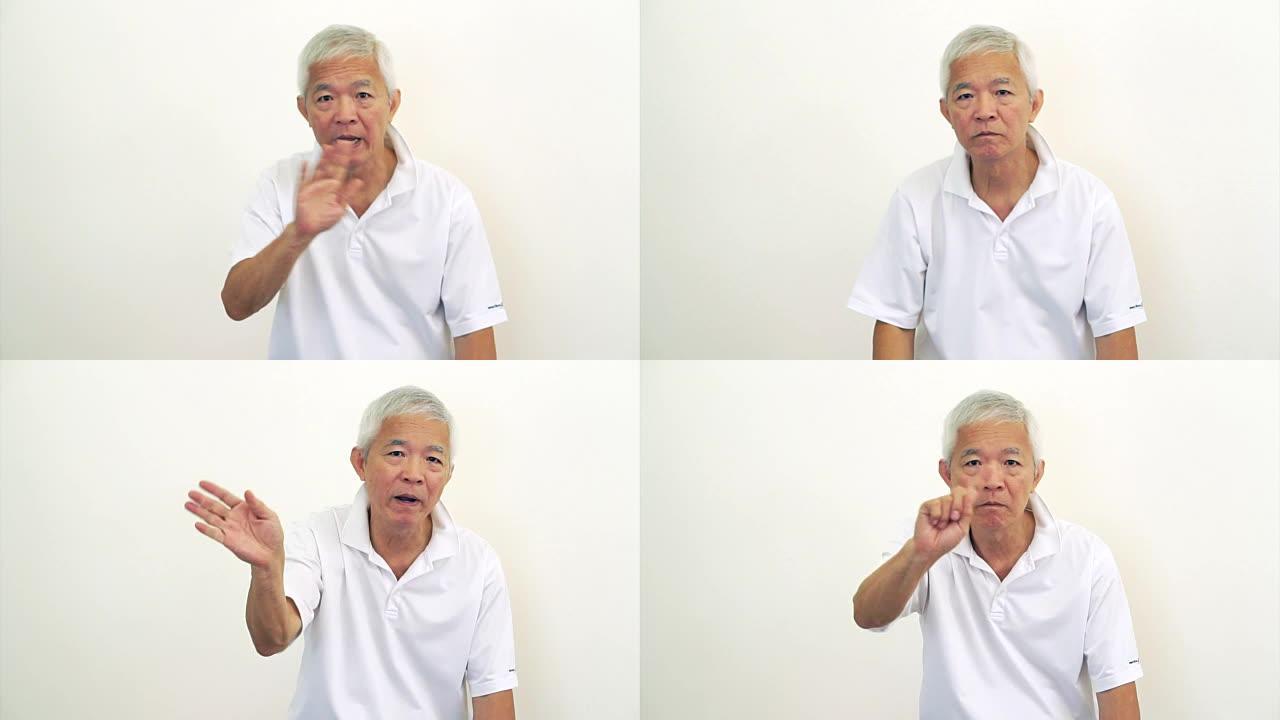 亚洲男子老人看着相机摇头，做手势拒绝，说不