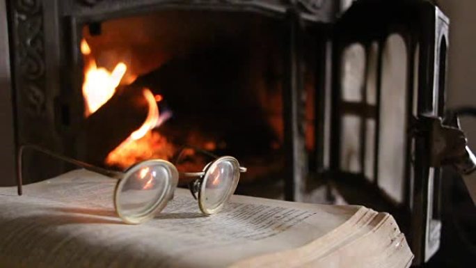 眼镜、打开的书和壁炉