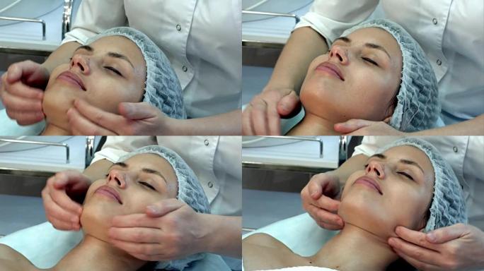 美丽的年轻女子在水疗中心享受闭着眼睛的面部按摩