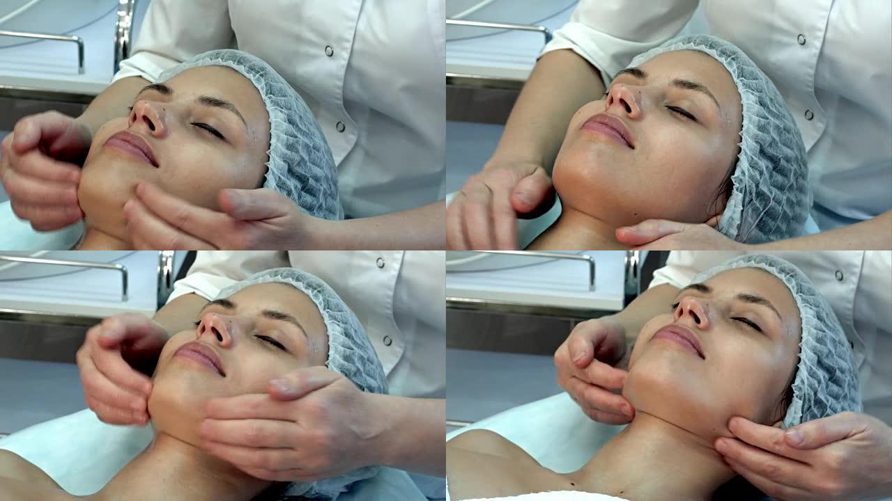 美丽的年轻女子在水疗中心享受闭着眼睛的面部按摩