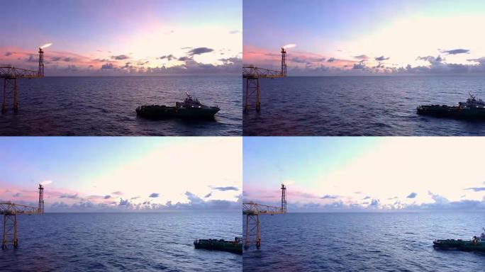 油气平台的延时镜头，带有火炬燃烧桥，太阳升起，早晨美丽的云彩，为油气工业概念和供应工业船。
