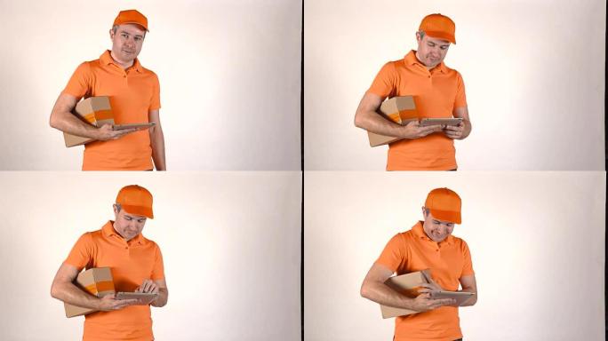 穿着橙色制服的送货员使用他的平板电脑给顾客一个包裹。灰色背景全高清孤立镜头