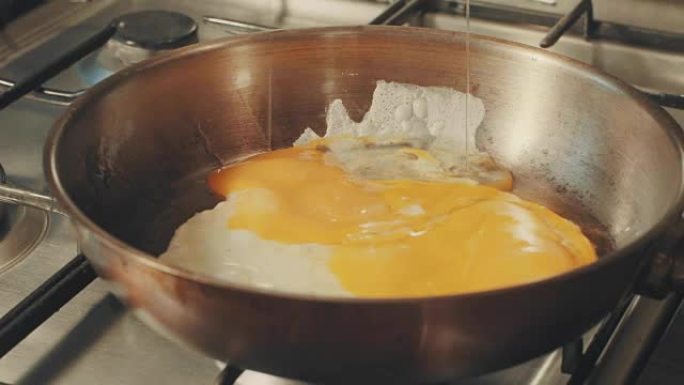 有人在锅里倒油，打碎鸡蛋，然后油炸