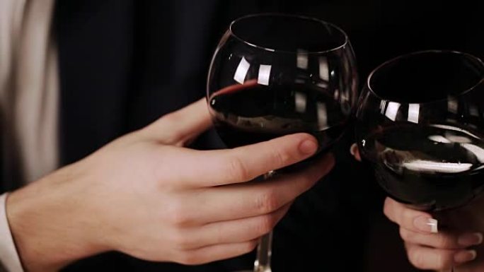 幸福的夫妇在一家高级餐厅里喝葡萄酒和碰杯