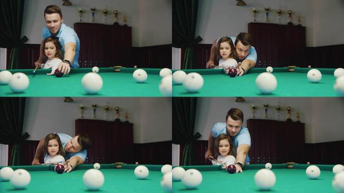 爸爸教女儿打台球。它展示了如何握杆