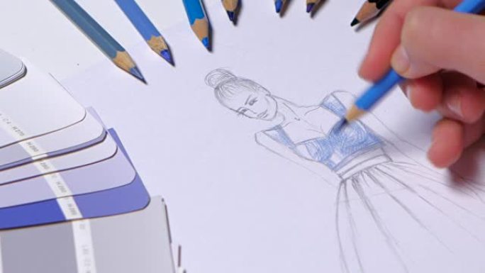 设计师服装装饰着蓝色的草图，在桌布样品上躺着。特写