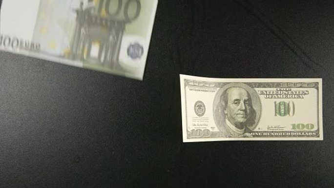 顶视图: 两张纸币躺在一张黑桌子上，然后欧元飞走了