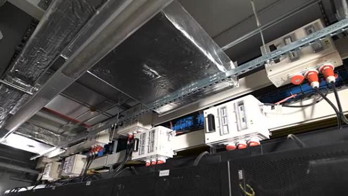 几个电力设备内部装有一个开关，该开关安装在IT公司工业场所的天花板下。通过带有红色插头的电缆连接到公