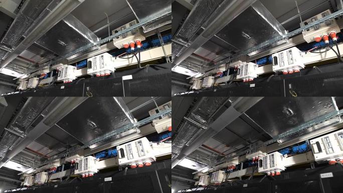几个电力设备内部装有一个开关，该开关安装在IT公司工业场所的天花板下。通过带有红色插头的电缆连接到公