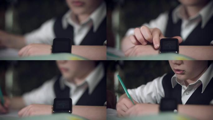 4k高科技拍摄的孩子在智能手表上做作业并检查时间