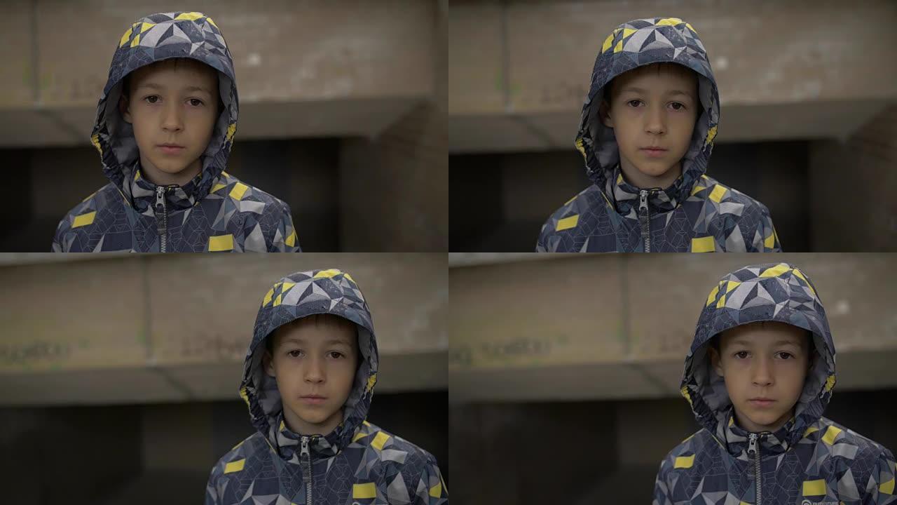 严肃的男孩看着镜头特写，躲着隧道里的雨