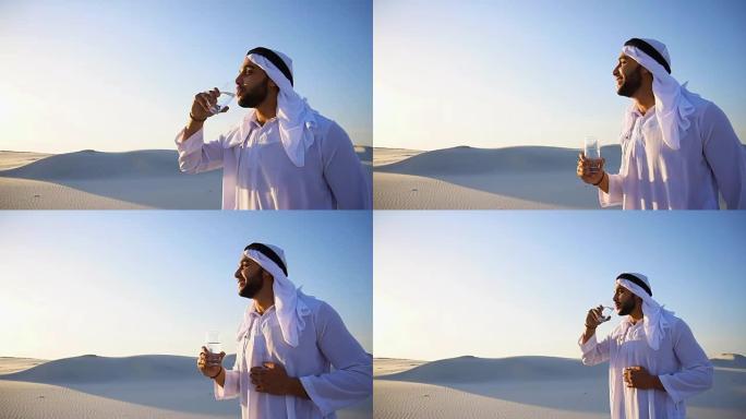 在沙质沙漠干燥的气候中，男性穆斯林的清新气息。guy Arab在晚上露天从玻璃中喝水