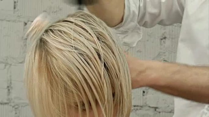 理发师用吹风机吹干女人的头发