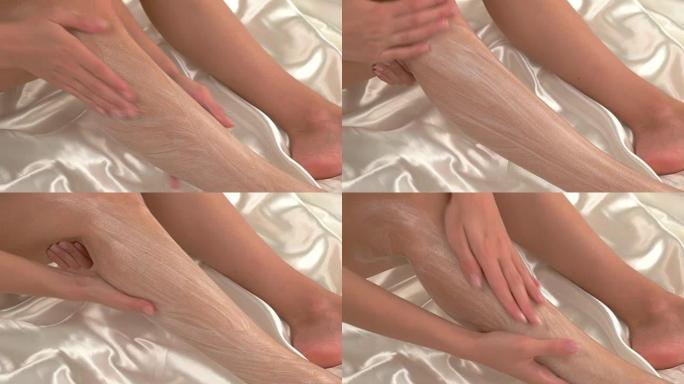 女人在腿上涂奶油。