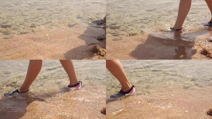 女孩穿着胶鞋走进海里，很慢。
