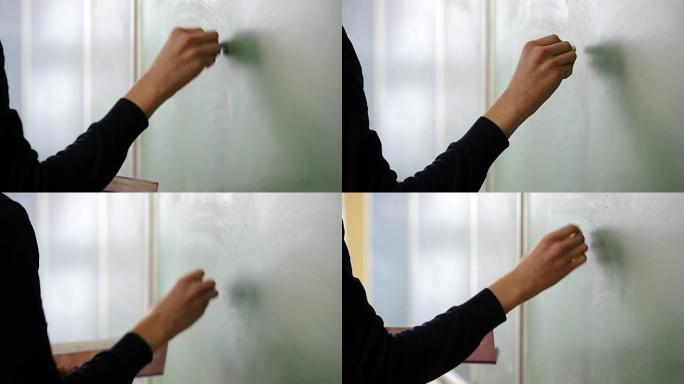 学生站在黑板前用粉笔书写