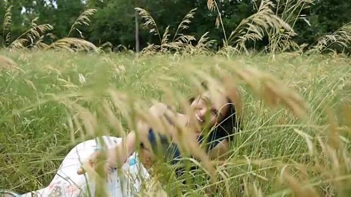 一个漂亮的女孩躺在一个斑斓的草坪上，以慢动作沉思地望着外面