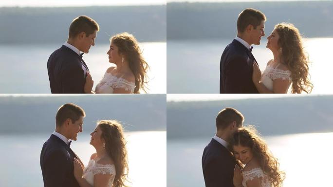 迷人的微笑的妻子和她的丈夫在他们一生中最美好的一天接吻。婚礼当天。